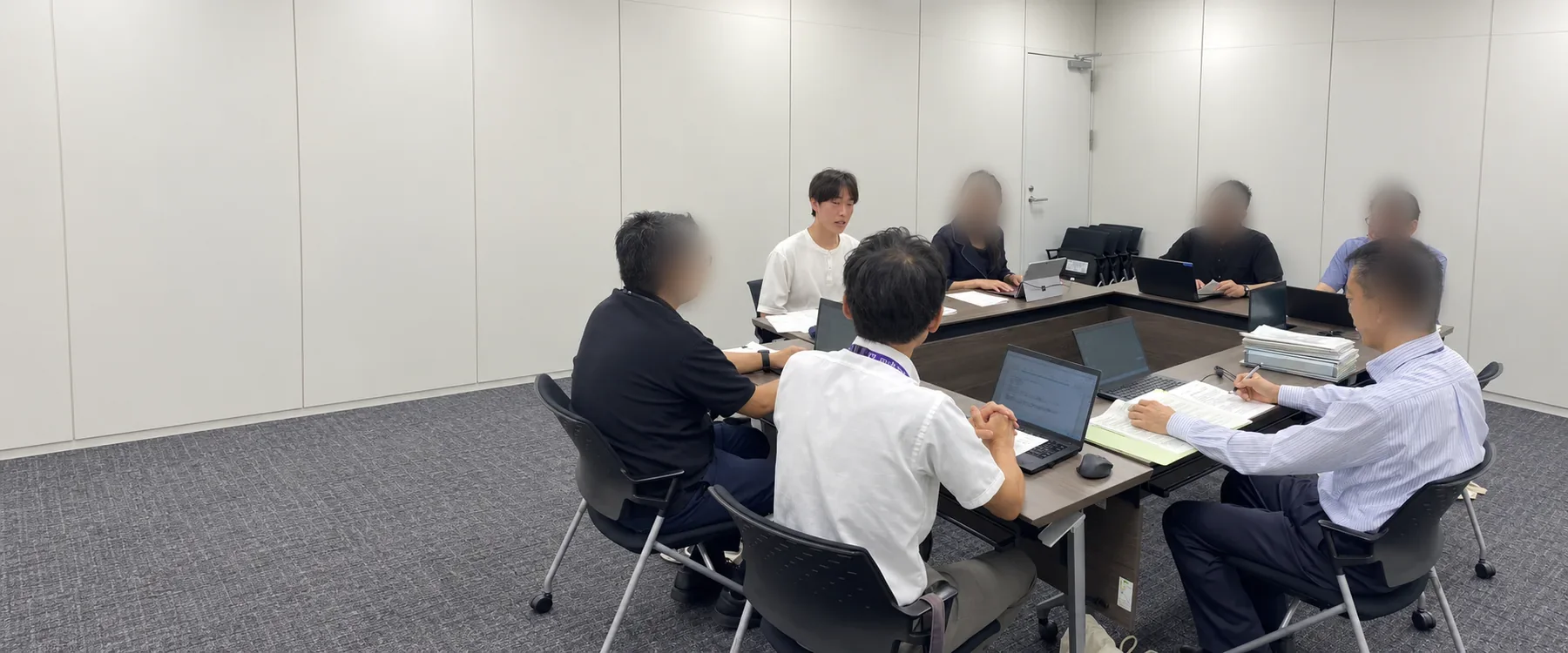 行政の担当者と会議で議論する高校生