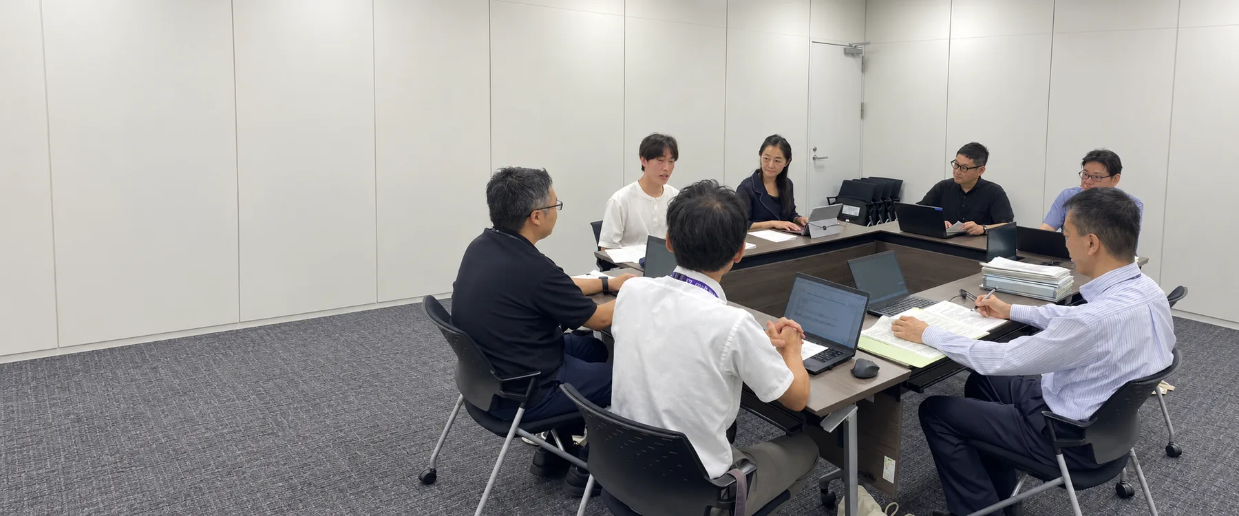 行政の担当者と会議で議論する高校生